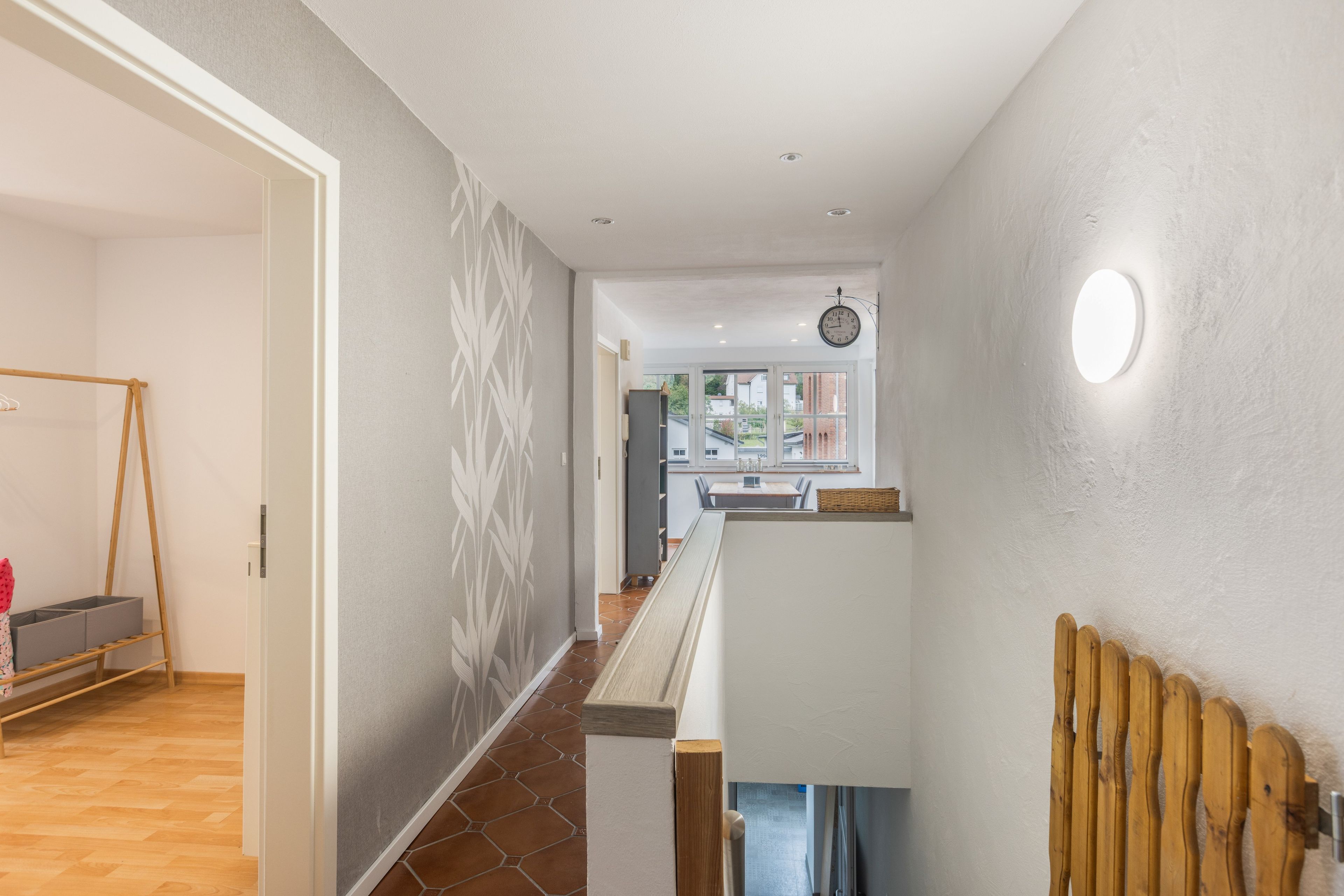 Ein modernes Interieur mit einer Treppe, einer Holzbank und Blick ins Freie.