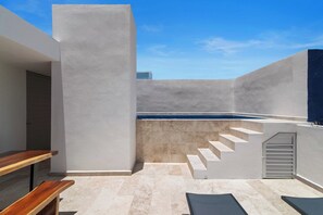 Ein moderner Außenbereich mit Swimmingpool, einer Treppe und einer Holzbank.
