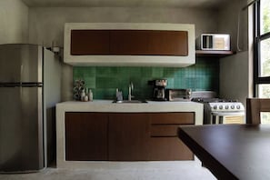 A kitchen with a built-in stove, a refrigerator, a microwave, and a coffee maker. - Suk-Ha Condo with Rooftop | La Veleta, Tulum (Tulum)