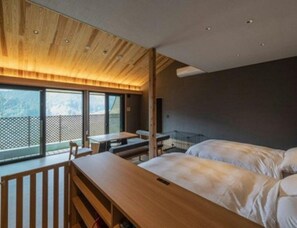 A modern hotel room with a wooden ceiling, a balcony with a view, and a bed with white bedding. - Furuyu Onsen Ryokan Suginoya (Saga)