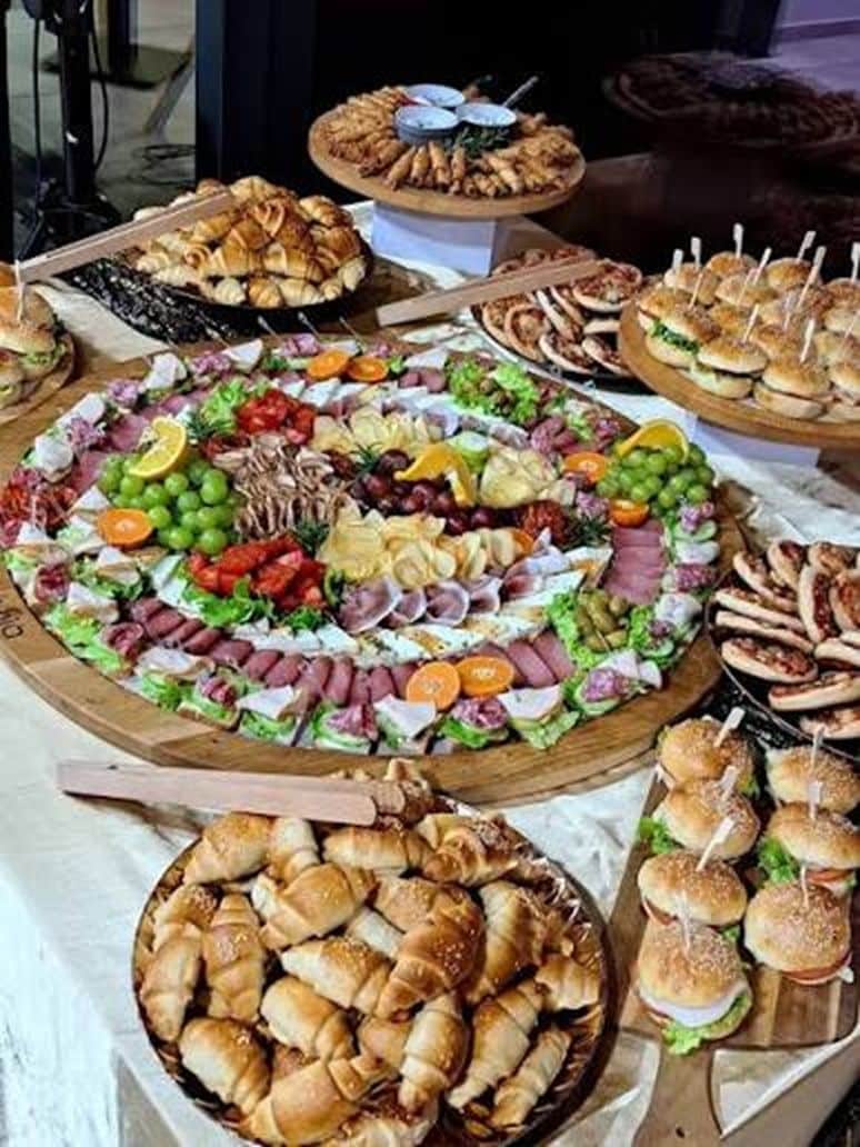 A variety of food items displayed on a table, including a large platter of assorted cheeses, meats, and vegetables.