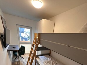 A compact room with a bunk bed, a desk, and a chair. - Villa Trisatus on the Lake (Goehren-Lebbin)