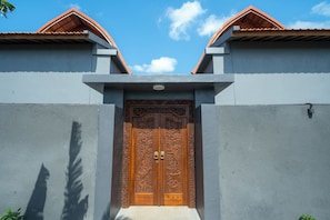 Un bâtiment doté d’une grande porte en bois richement décorée et d’une façade symétrique.