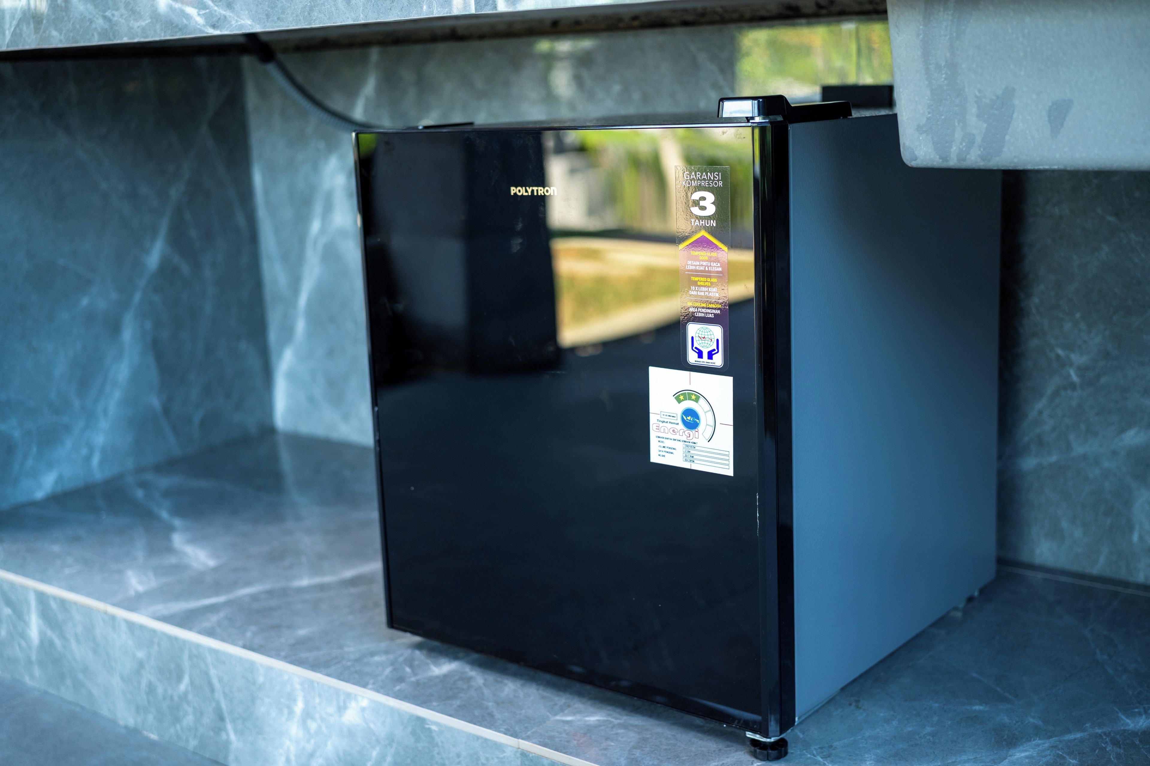 Ein schwarzer Kühlschrank mit einem Aufkleber, der eine 3-jährige Garantie kennzeichnet.