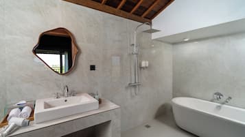 Un baño moderno con una bañera independiente, un tocador con lavamanos y una ducha con cabezal de ducha manual.