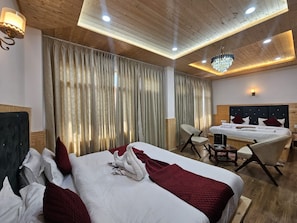 A hotel room with a large bed, a desk, and a chair.
