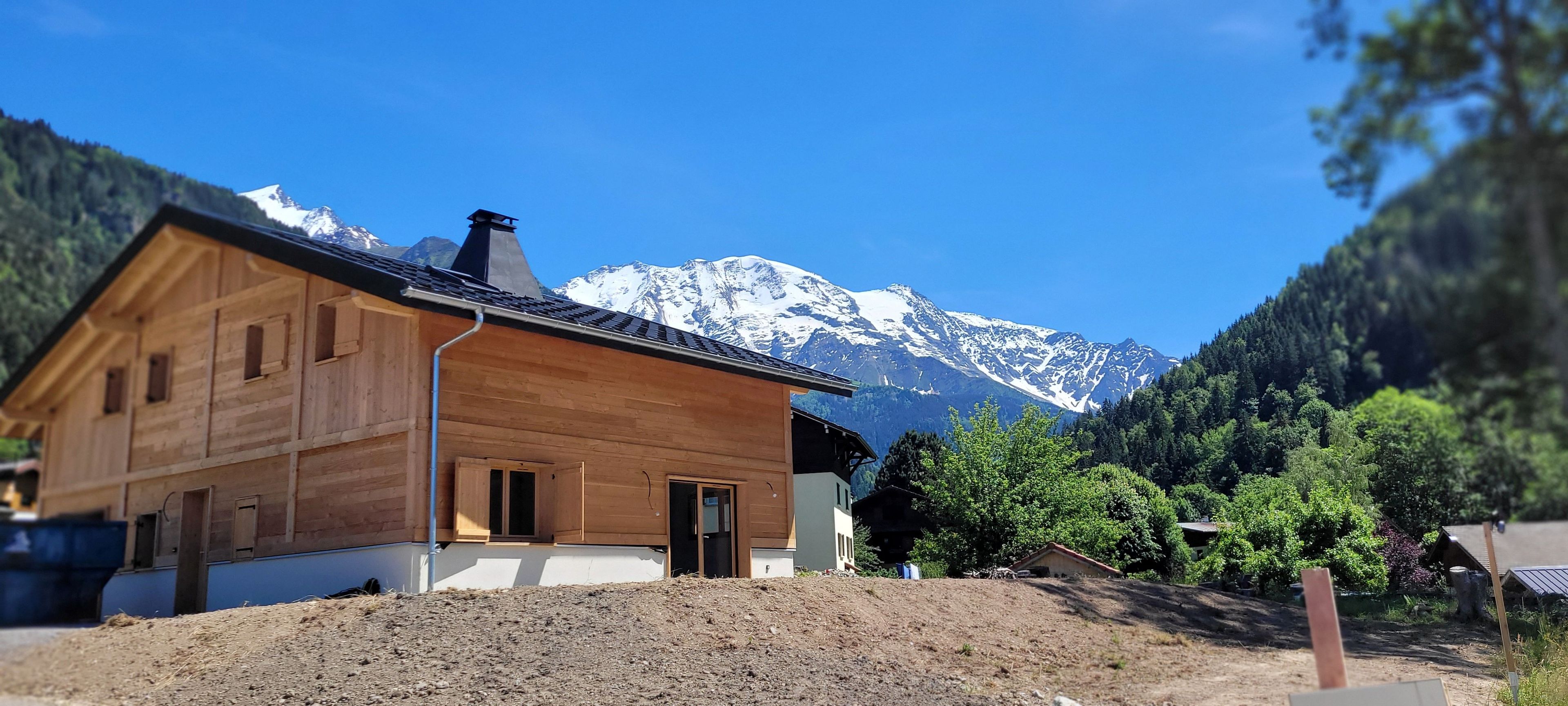 Une cabane en bois offrant une vue sur des montagnes enneigées.