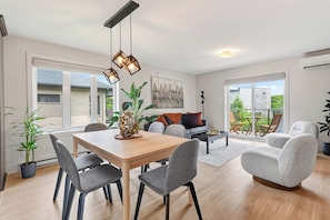 A modern interior with a dining area, seating, and a view to the outside. - L'Écrin: Contemporary elegance and cozy comfort in the heart of the city. (Québec)