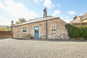 A stone building with a blue door, two windows, and a chimney. - Host and Stay - The Cottage ALN (Alnwick)