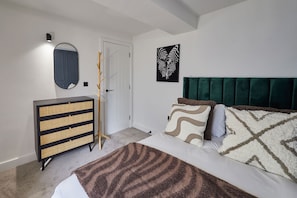 A bedroom with a bed, a dresser, a mirror, and a door. - Host Stay - The Premier Loft (Middlesbrough)