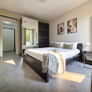 A modern bedroom with a large bed, a walk-in closet, and a view of the outdoors. - Casa Michela - 20 Minutes to the City Center (Scandicci)
