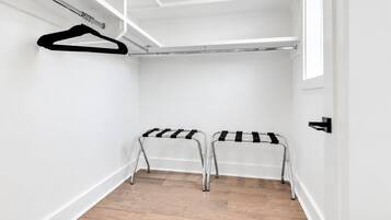 A walk-in closet with two metal drying racks and a white door.