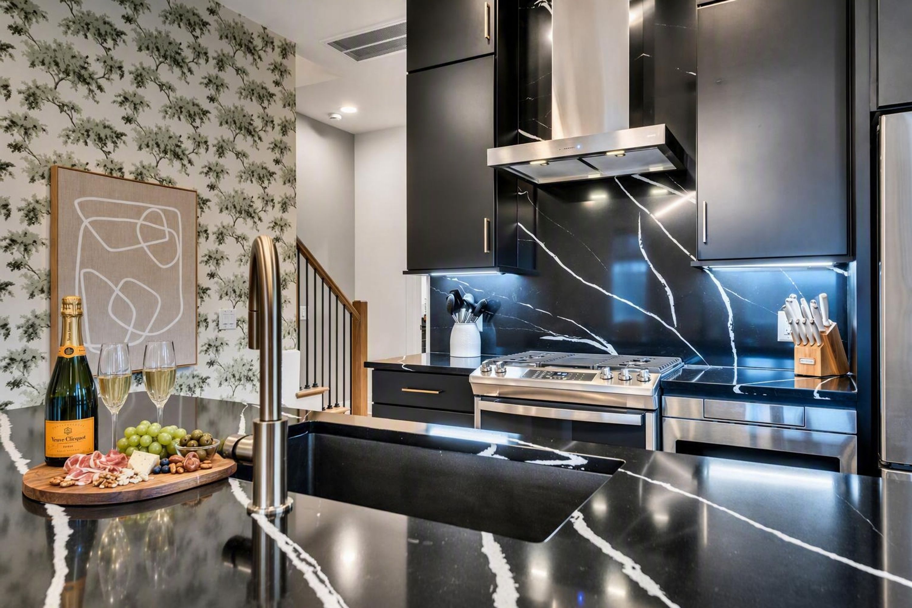 A modern kitchen with a marble countertop, stainless steel appliances, and a decorative backsplash.