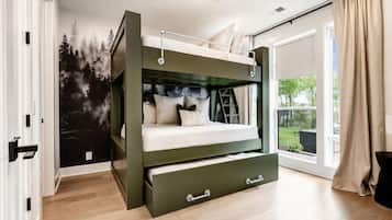 A bunk bed with a lower bunk drawer, a forest mural on the wall, and a sliding glass door to the outside.