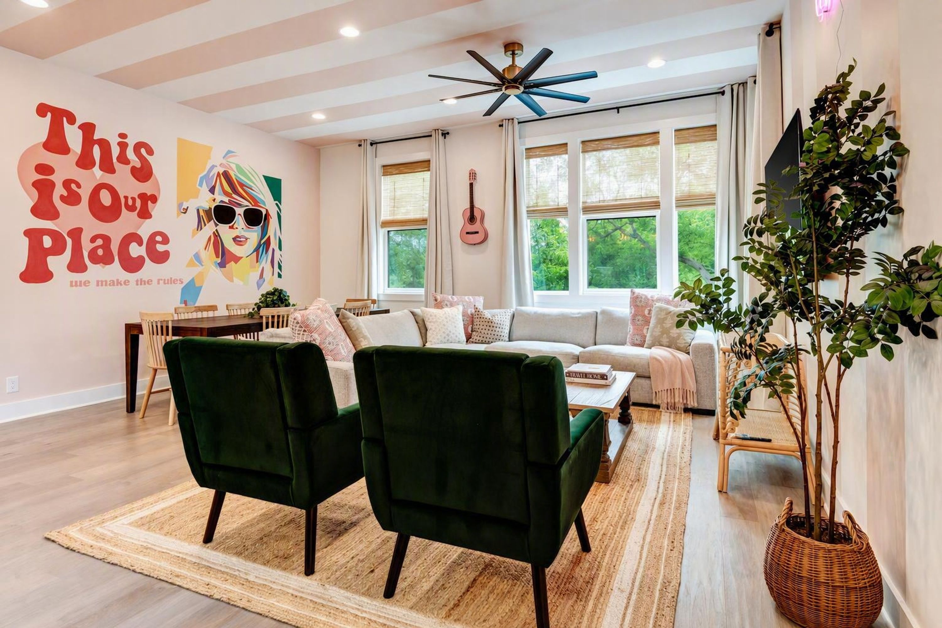 A modern living room with a green sofa, a coffee table, and a large window with blinds.