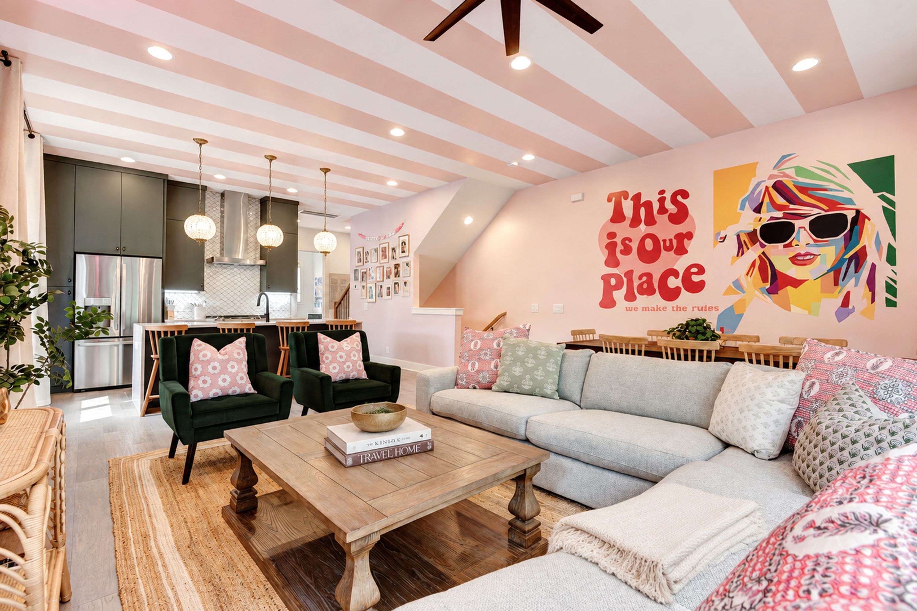 A modern living space with a kitchen, dining area, and a large wall mural.