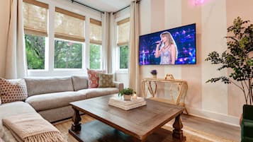 A modern living room with a sofa, coffee table, and a flat-screen TV mounted on the wall.