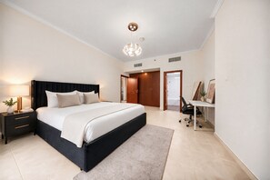 Ein modernes Schlafzimmer mit einem großen Bett, Nachttischen, einem Schreibtisch und einem Stuhl.