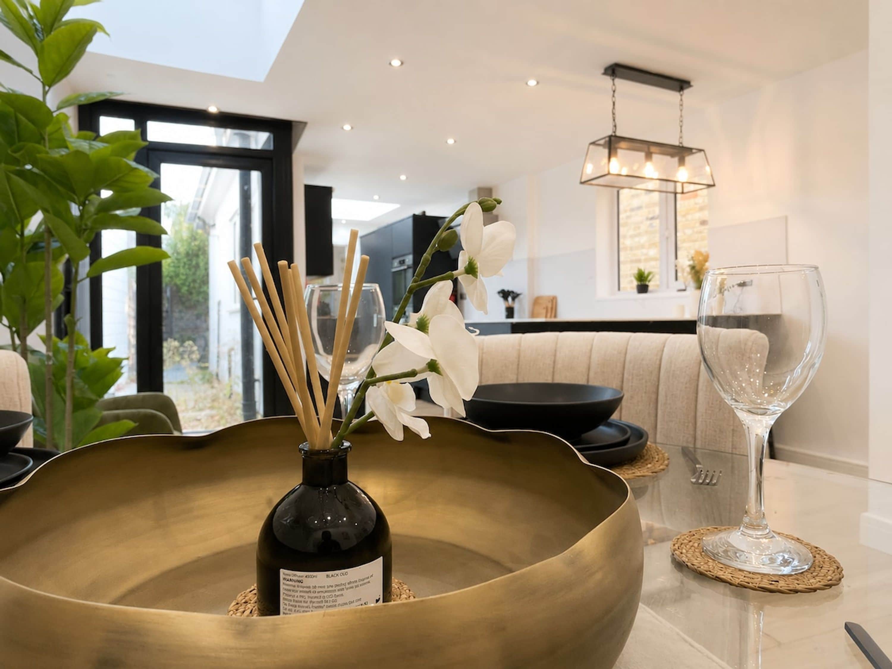 A modern interior with a large bowl centerpiece, a wine glass, and a bottle of Black Oolong tea.