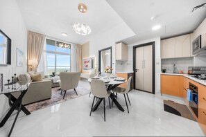 A modern interior with a dining area, kitchen, and living space. - Stayshort - Premium New Studio in Arjan That Sleeps 4 (Dubai)