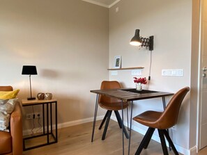 Ein moderner Essbereich mit Tisch, Stühlen, einer Lampe und einer Wandleuchte.