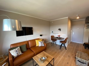Ein modernes Wohnzimmer mit einer Couch, einem Couchtisch und einem Essbereich.