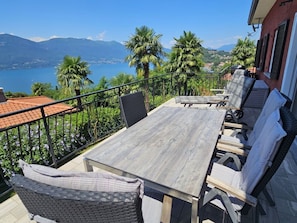 Eine Außenpatio mit Tisch und Stühlen, mit Blick auf einen See und Berge.