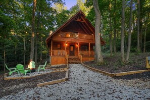 A cabin with a balcony, surrounded by trees, and a gravel path leading to the entrance. - Emerald Ridge Log Cabin~Hot Tub~Near Hocking Hills (Logan)