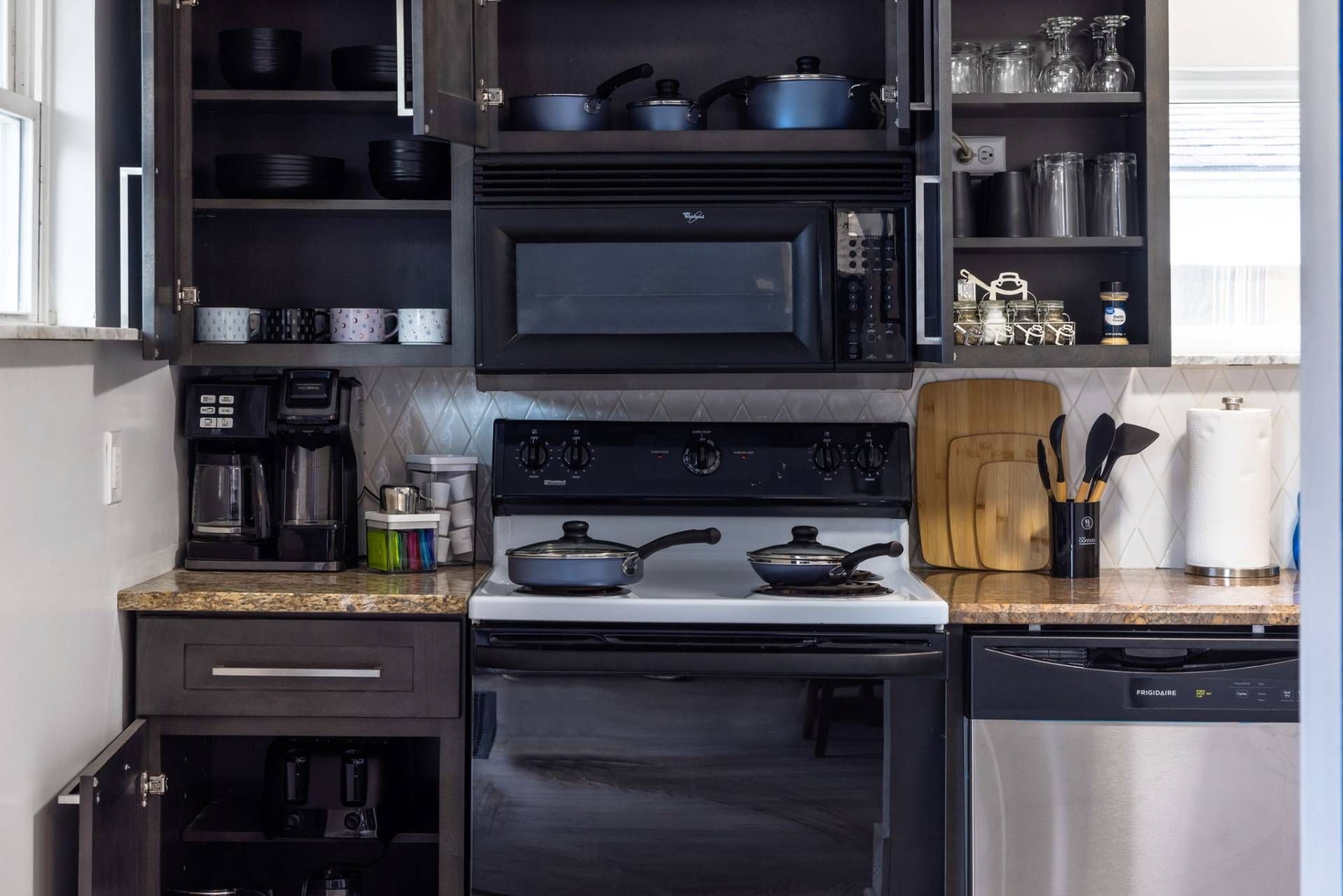 Electric range, microwave and dishwasher, with cookware and cutting boards ready