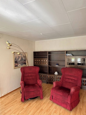 A room with two red armchairs, a wooden cabinet with glass doors, and a painting on the wall. - Tranquil Alta House, 3 Bedrooms, Private Entrance, Scenic Views (Alta)
