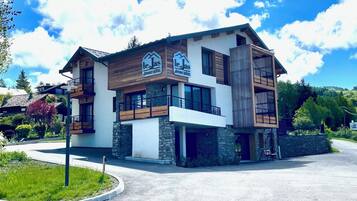 Un hotel moderno su due piani con facciata in pietra, elementi in legno e balconi.