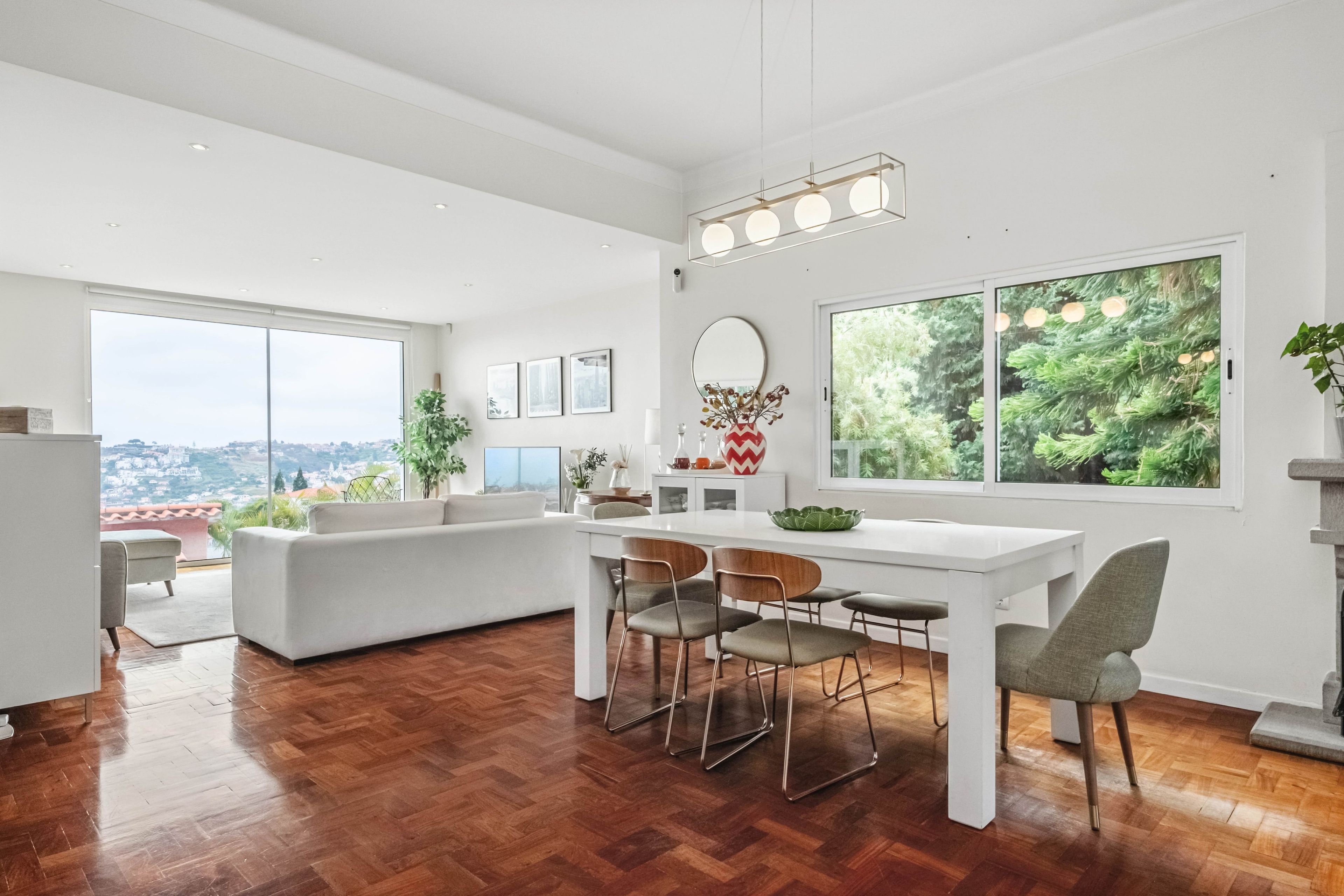 Eine moderne Küche mit Essbereich, großen Fenstern und Blick auf die Stadt.