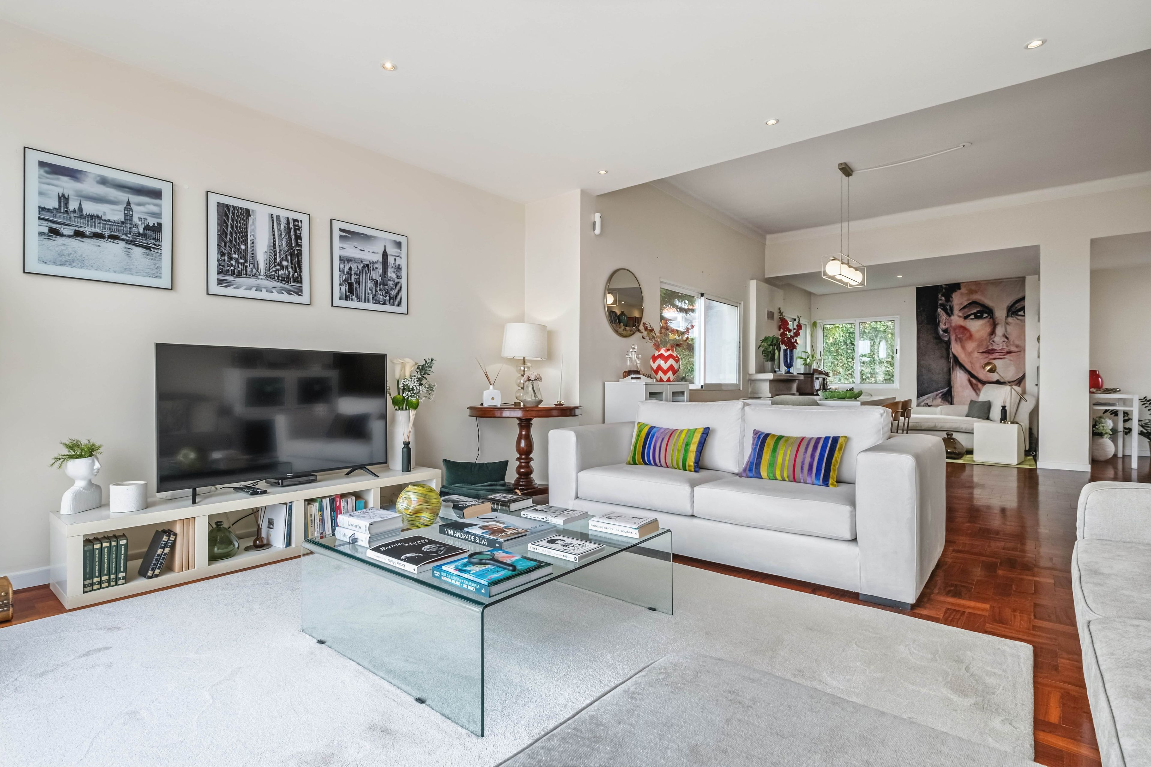A modern living room with a flat-screen TV, books, and a coffee table.