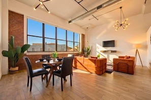 A spacious living area with a dining table, sofas, and a TV. - Near NYC, Gym, Patio & Parking - Premium Stay (Kearny)