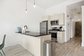 Eine moderne Küche mit einer zentralen Kochinsel, Edelstahlgeräten und minimalistischem Design.