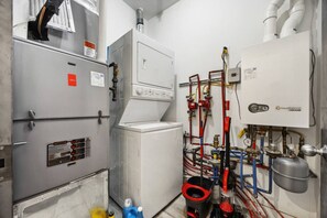 Ein Technikraum mit HLK-Anlagen, Warmwasserbereitern und komplexen Rohrleitungssystemen.