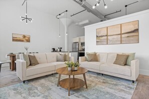 Ein modernes Wohnzimmer mit einem Ecksofa, einem Couchtisch und Kunstwerken an den Wänden.