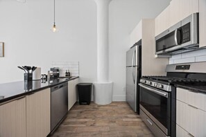Eine moderne Küche mit Kochinsel, Edelstahlgeräten und minimalistischem Design.