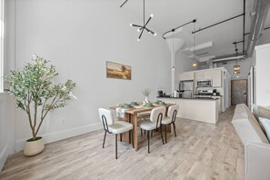 Eine moderne Küche mit einer zentralen Kochinsel, einem Holzespeisetisch und Stühlen.