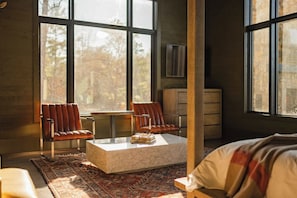 Ein Zimmer mit großem Fenster, einer Couch, einem Couchtisch und einem Schrank.