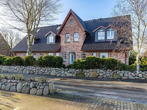 A two-story house with a stone foundation, a steeply pitched roof, and a brick facade. - Holiday Home in Sylt With 3 Bedrooms (Sylt)