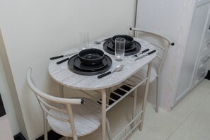 A small dining table with two black plates, a glass, and cutlery. - StayShort - Spacious 11-Bedroom Villa Stay at Casa Royale, JVC (JVC)