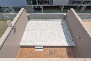 A rooftop terrace with a marble floor and a brick pattern at the base. - StayShort - Spacious 11-Bedroom Villa Stay at Casa Royale, JVC (JVC)