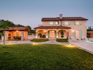 A two-story house with a patio, outdoor seating, and a swimming pool. - Villa in Kras With Swimming Pool (Dobrinj)