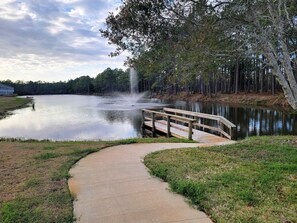 A lake with a wooden bridge and a waterfall. - New to Program | Santa Rosa Sunshine | 3BR Retreat with Pool, Lake (Santa Rosa Beach)