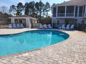 A swimming pool with lounge chairs and a covered area, surrounded by a brick patio. - New to Program | Santa Rosa Sunshine | 3BR Retreat with Pool, Lake (Santa Rosa Beach)