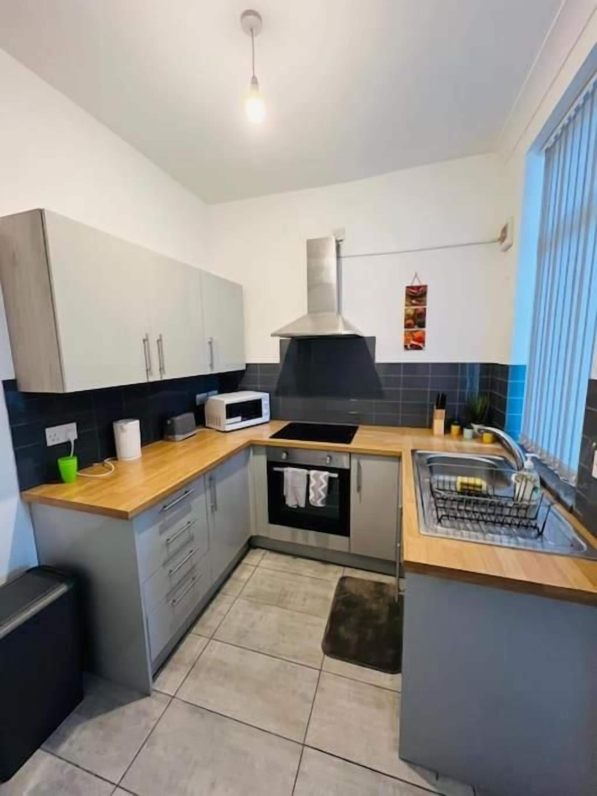 A compact kitchen with a microwave, oven, and sink.