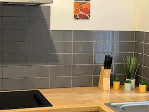 A kitchen with a black stove, a knife block, and potted plants. - 4 Bedroom House all En-suite rooms. (Stoke-on-Trent)