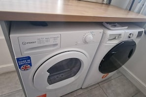 A white washing machine with a control panel and a label indicating it is made in Britain. - 4 Bedroom House all En-suite rooms. (Stoke-on-Trent)