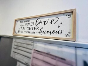 A framed sign with the text 'THIS HOUSE RUNS ON love. LAUGHTER & INAPPROPRIATE HUMOUR.' - 4 Bedroom House all En-suite rooms. (Stoke-on-Trent)